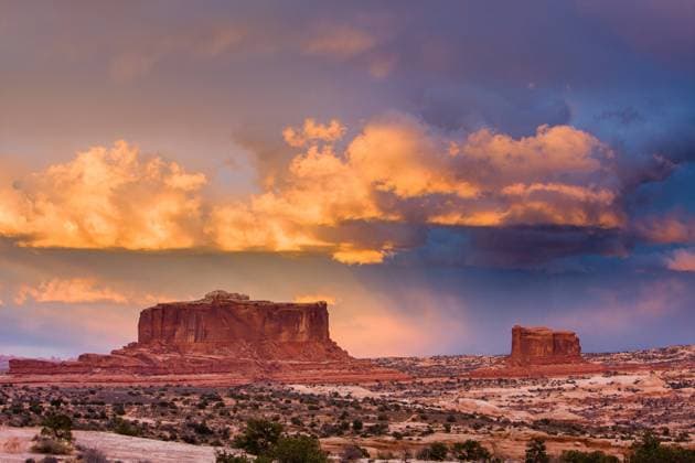 Colorful sunset clouds over the Monitor and Merrimac Buttes near Moab, Utah. Moab Utah United States Copyright: xJonxG.xFullerx xVWPicsx 4839-JGF-landscapes-Monitor & Merrimac-US-UT