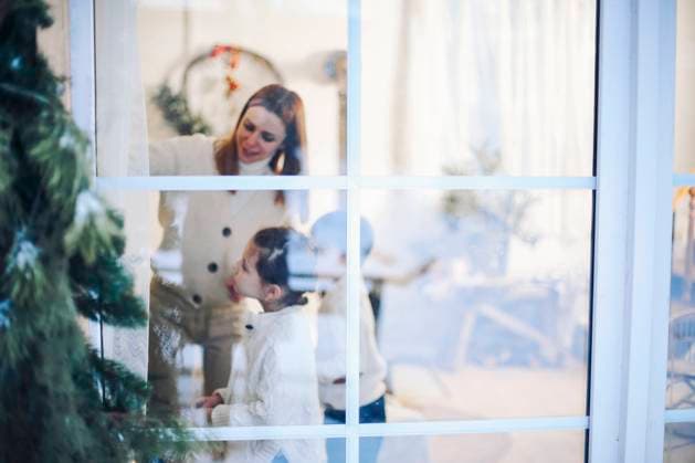 Christmas time. Happy family with two little kids gathered at window at home decorating xmas tree. Christmas time. Portrait of family with two little kids gathered at window at home decorating xmas tree together, happy parents and children anticipating arrival of winter holidays, selective focus Copyright: xZoonar.com DashaxPetrenkox 19386549 ,model released, Symbolfoto ,property released