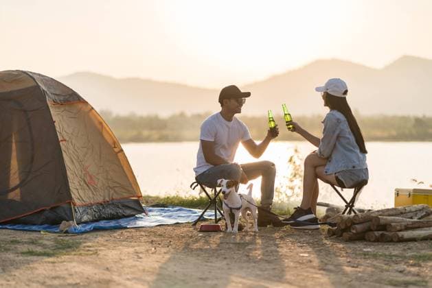 Young adult Asian couple drinking beer beside their tent with dog Young adult Asian couple drinking beer beside their tent campsite while sunset. Camping trip with dog outdoor activity campsite concept. Copyright: xZoonar.com VichayaxKiatying-Angsuleex 16422249 ,model released, Symbolfoto ,property released