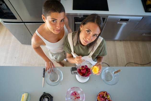 Young woman with friend preparing prickly pear juice in kitchen at home model released, Symbolfoto property released, FBAF02058