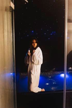 Thoughtful woman wearing bathrobe standing in swimming pool model released, Symbolfoto property released, JJF00117