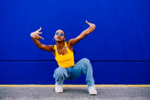 Young woman in squatting in front of blue wall model released, Symbolfoto, OIPF03073