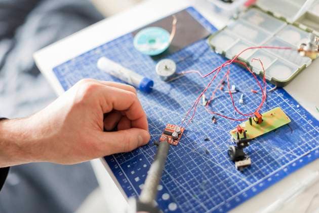 Hand of technician soldering circuit board at workshop model released, Symbolfoto property released, ONAF00413