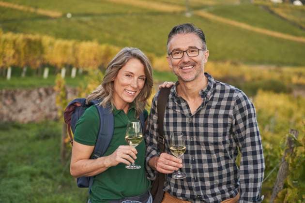 IMAGO Creative, Sommer, Weinfeste und Weinwanderungen Mature couple holding wineglasses on hill model released, Symbolfoto, RORF03377