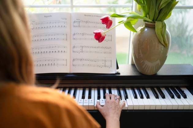 Woman playing piano in living room at home model released, Symbolfoto property released, SVKF01209