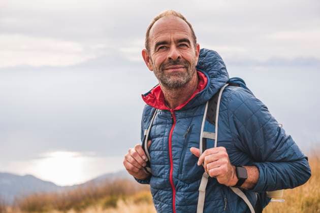 Smiling mature man with backpack standing under sky model released, Symbolfoto, UUF28232