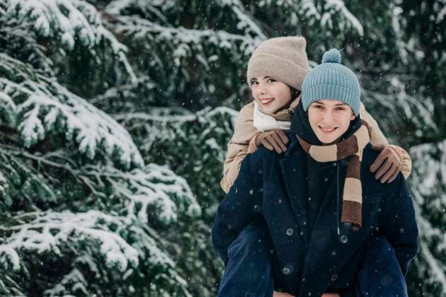 Smiling boy piggybacking girlfriend at park in winter model released, Symbolfoto, VSNF00420