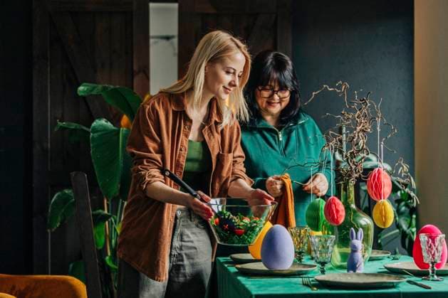 Happy woman with mother setting table for Easter dinner at home model released, Symbolfoto property released, VSNF00461