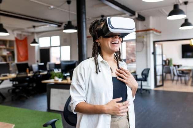 Happy businesswoman wearing VR glasses standing in office model released, Symbolfoto property released, WPEF07116