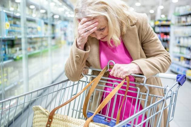 15 February 2023: Elderly sad woman shopping in supermarket and worrying about rising costs - symbol image rising prices, inflation. Woman holding her head worried *** Ältere traurige Frau beim Einkaufen im Supermarkt und macht sich Sorgen über steigende Kosten - Symbolbild steigende Preise, Inflation. Frau hält sich besorgt den Kopf