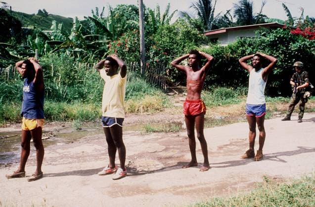 RECORD DATE NOT STATED A member of the 82nd Airborne Division guards suspected members of the People s Revolutionary Army who were captured during Operation URGENT FURY. Subject Operation Series: URGENT FURY Country: Grenada (GRD) Copyright: xpiemagsx nararecdefpie08012022-37811 !ACHTUNG AUFNAHMEDATUM GESCHÄTZT!
