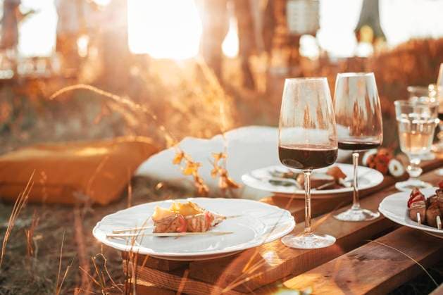 Wooden table with glassware arranged for picnic Set of elegant glassware placed on plank wooden table with floral arrangement on grassy meadow during festive autumn picnic Copyright: xZoonar.com DashaxPetrenkox 16822225 ,model released, Symbolfoto ,property released