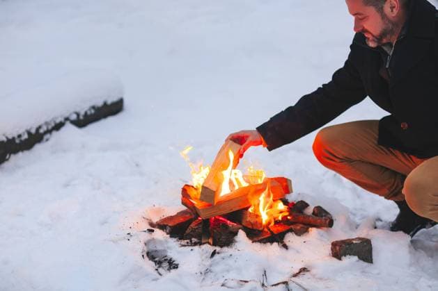 Mature man warming his hands with campfire in snowy forest Mature man warming his hands with fire after making campfire in middle of snowy forest in cold winter evening, using heat to feel good and comfortable in bad weather, enjoying winter holidays Copyright: xZoonar.com DashaxPetrenkox 17561222 ,model released, Symbolfoto ,property released