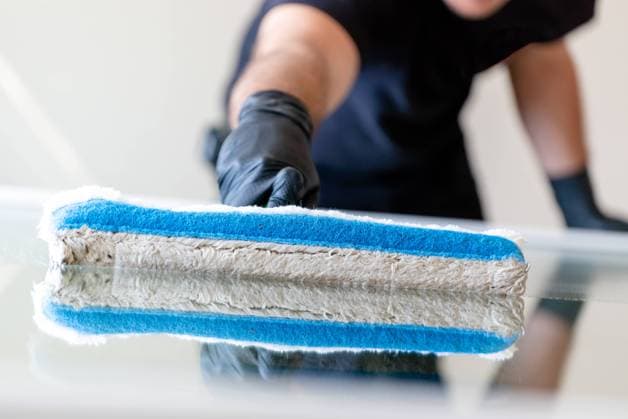 professional window cleaner using a window cleaning washer sleeve to cleanse a large fold down apartment window A professional window cleaner using a window cleaning washer sleeve to cleanse a large fold down apartment window Copyright: xZoonar.com NandoxLardix 15512101 ,model released, Symbolfoto ,property released