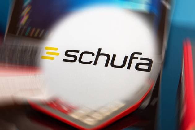 Symbolbild Schufa(Auskunft): Schufa-Logo vor einem Schreibtisch mit Tablet, Taschenrechner und Kontoauszügen *** Symbol image Schufa information Schufa logo in front of a desk with tablet, calculator and bank statements Copyright: xx