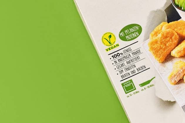 Verpackung eines veganen Fleischersatzprodukts mit Etikett und deutschem Text auf grünem Hintergrund mit Kopierraum, Deutschland, Europa *** Packaging one vegan meat substitute product with Label and German Text at green Background with Copy room, Germany, Europe Copyright: imageBROKER Firn ibxmob09084864.jpg