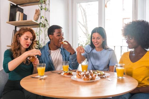  Multiethnische Freunde bei einem Frühstück mit Orangensaft und Muffins zu Hause, Details beim Schneiden der Toasts *** multiethnic Friends at a Breakfast with Orange juice and Muffins to home, Details at Cutting the Toasts Copyright: imageBROKER/UnaixHuizi ibxuhu09108086.jpg ,model released, Symbolfoto ,property released
