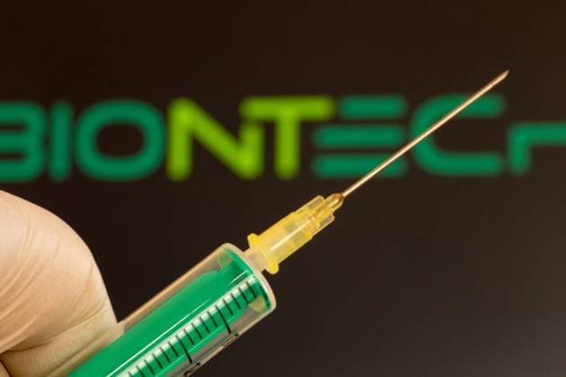 Symbolbild Coronaimpfung Biontech: Nahaufnahme einer Injektionsnadel, im Hintergrund das Logo von Biontech. Die Debatte über mögliche Impfschäden nimmt in Deutschland derzeit an Fahrt auf *** Symbolic image Corona vaccination Biontech Close-up of an injection needle, Biontech logo in the background The debate about possible vaccination damage is currently gaining momentum in Germany Copyright: xx