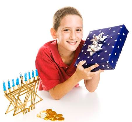 Adorable little boy with a Chanukah gift, menorah, dreidel and gelt. Isolated on white. Copyright: xLisaxF.xYoungx xDesignxPicsx , 30450163 Copyright: LisaxF.xYoungx xDesignxPics 30450163