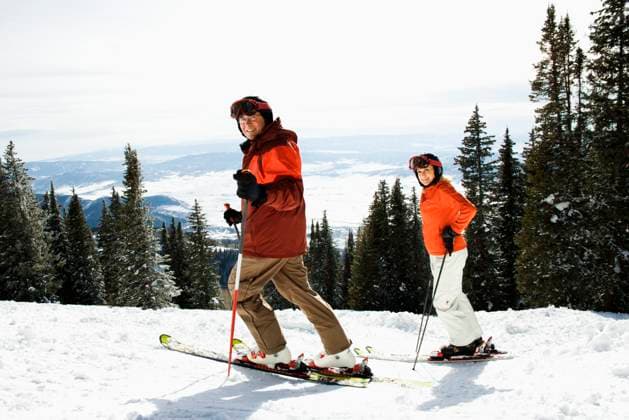 Side view of skiers on a snowy ski slope with trees and valley in background. Horizontal shot. Copyright: xIofotoxImagesx xDesignxPicsx , 30469770 Copyright: IofotoxImagesx xDesignxPics 30469770