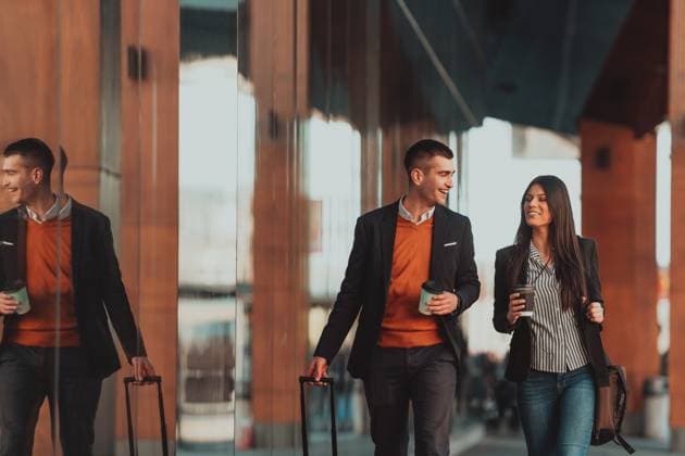 Business man and business woman talking and holding luggage traveling on a business trip Businessman and businesswoman talking and holding luggage traveling on a business trip, carrying fresh coffee in their hands. Business concept. High-quality photo ,model released, Symbolfoto Copyright: xZoonar.com benisxarapovicx 17138337 ,model released, Symbolfoto ,property released