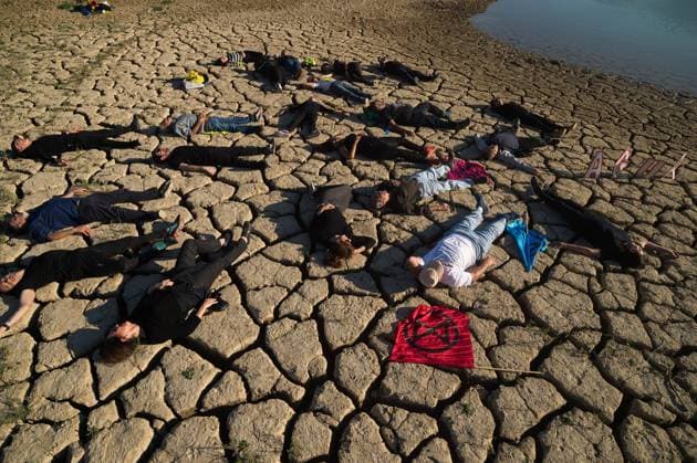 News Themen der Woche KW12 March 22, 2023, Malaga, Spain: Environmental and human rights activists are seen over cracked ground during a protest against climate change, organized by Amnesty International. To mark International Water Day, activists from Amnesty International, along with several environmental organizations, have denounced climate change and its effects on human rights around the world through a performance that represents the symbolic death of the La Vinuela reservoir. The Vinuela reservoir, which supplies water to the municipalities near the Axarquia region, is at minimum water levels due to the serious drought in the province. Malaga Spain - ZUMAs197 20230322_zaa_s197_194 Copyright: xJesusxMeridax
