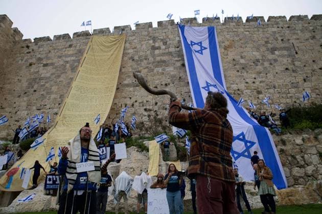News Themen der Woche KW12 March 23, 2023, Jerusalem, Israel: A man in Jerusalem wears tefilin, which are leather straps and boxes containing sacred parchments, and blows a shofar in protest. Demonstrators have draped the national flag of Israel and copies of the Israeli Declaration of Independence on the walls of the city s Old City to protest against the judicial overhaul being pursued by the country s Prime Minister, Benjamin Netanyahu. Jerusalem Israel - ZUMAs197 20230323_zaa_s197_009 Copyright: xMatanxGolanx