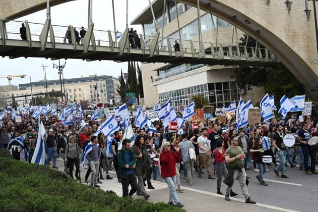 Israelis carry the national flag during a protest march for democracy and against Prime Minister Benjamin Netanyahu s judicial reforms on Thursday, in Jerusalem, March 23, 2023.  JER2023032305 DEBBIExHILL