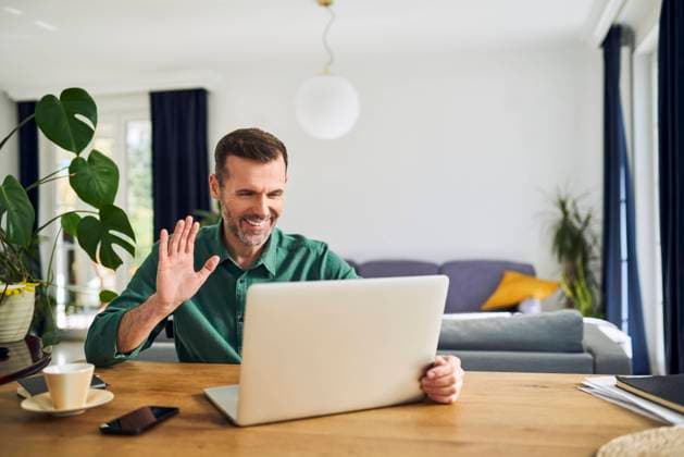 Cheerful man making video call waving at laptop model released, Symbolfoto property released, BSZF02223