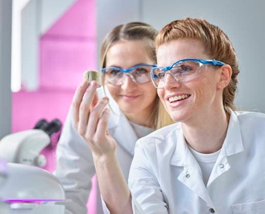 Happy scientist holding seed samples by colleague in laboratory model released, Symbolfoto property released, CVF02328