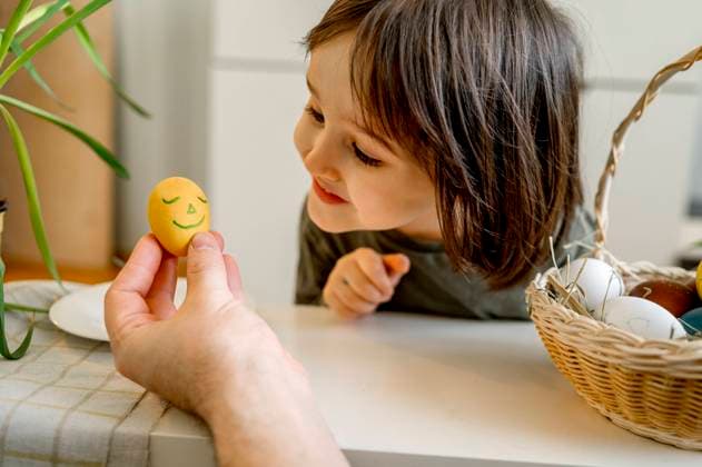Smiling boy looking at decorated Easter egg at home model released, Symbolfoto property released, ANAF01049