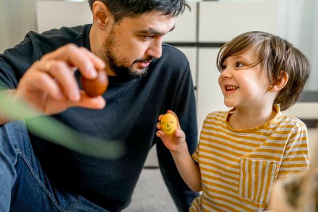 Father and son holding decorated eggs for Easter at home model released, Symbolfoto property released, ANAF01051
