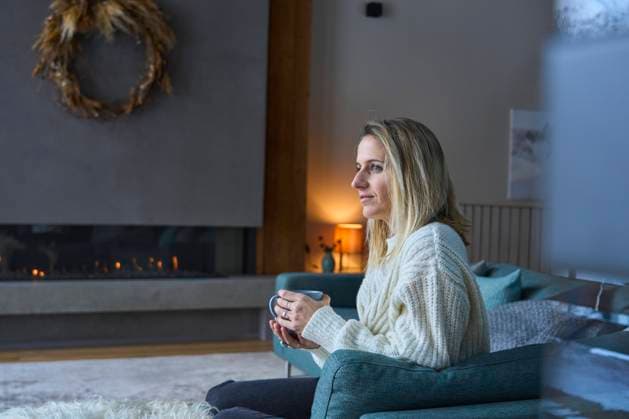 IMAGO Creative: Herbst, Gemütliches Zuhause Thoughtful woman with coffee cup on sofa at home model released, Symbolfoto property released, JAHF00289