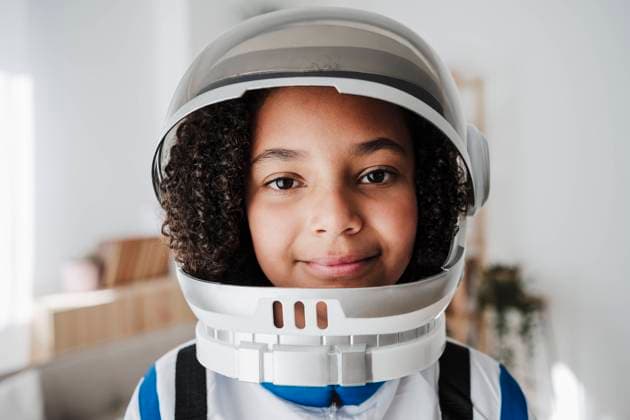 Creative Highlights Symbolbilder Smiling elementary girl wearing space suit at home model released, Symbolfoto property released, EBBF08253