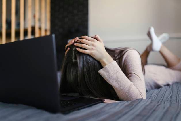 Tired woman lying on bed with laptop at home model released, Symbolfoto property released, ANNF00043