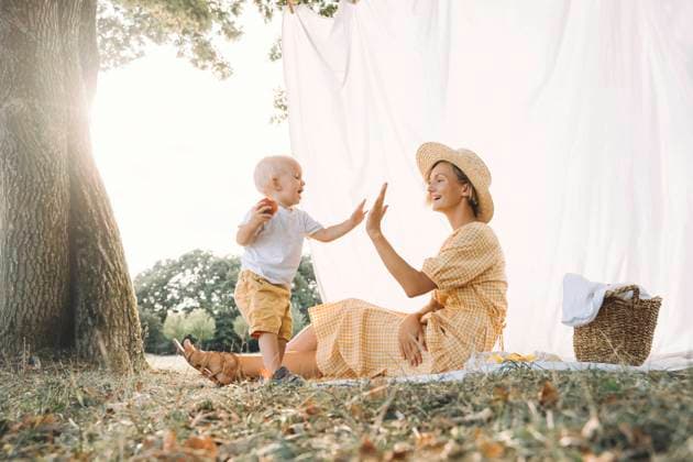 Creative Highlights Symbolbilder Happy mother giving high-five to son at park model released, Symbolfoto, NDEF00404