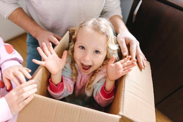 Creative Highlights Symbolbilder Happy girl sitting in cardboard box with sister and father at home model released, Symbolfoto property released, SIF00680