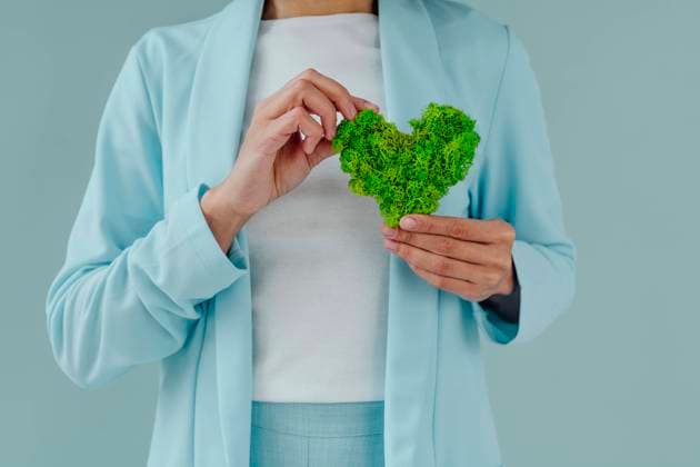 Creative Highlights Symbolbilder Woman holding green heart shape moss against blue background model released, Symbolfoto property released, YTF00592