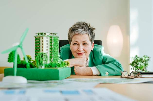 Creative Highlights Symbolbilder Smiling mature businesswoman looking at biophilic architectural model in office model released, Symbolfoto property released, YTF00635