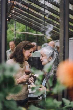 Senior female friends talking to each other at dinner party seen through glass Sweden, Stockholm, model released, property released Copyright: xMaskotx , MA100196 MA100196