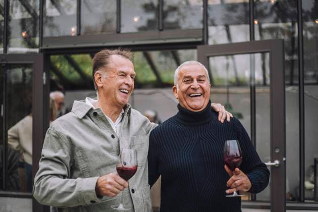 Happy retired male friends with wine enjoying at dinner party Sweden, Stockholm, model released, property released Copyright: xMaskotx , MA100199 MA100199