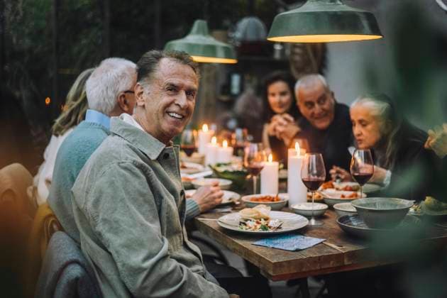 Portrait of happy senior man with friends during dinner party Sweden, Stockholm, model released, property released Copyright: xMaskotx , MA100234 MA100234