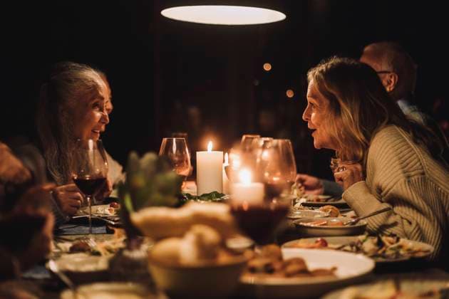 Senior woman talking to female friend at dining table during candlelight dinner party Sweden, Stockholm, model released, property released Copyright: xMaskotx , MA100264 MA100264