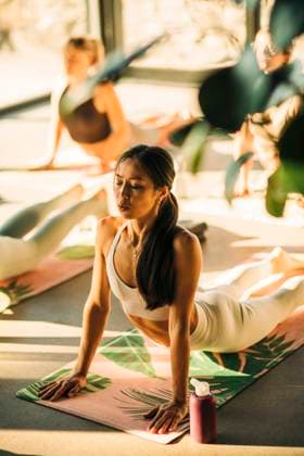 Young woman doing cobra stretch on exercise mat during yoga class at retreat center Sweden, Stockholm, model released, property released Copyright: xMaskotx , MA100317 MA100317