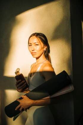 IMAGO Creative, Lifestyle, Tik Tok-Trend thatgirl Portrait of woman holding exercise mat while standing against wall Sweden, Stockholm, model released, property released Copyright: xMaskotx , MA100331 MA100331