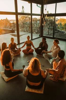 Multiracial female friends holding hands while meditating together at retreat center Sweden, Stockholm, model released, property released Copyright: xMaskotx , MA100355 MA100355