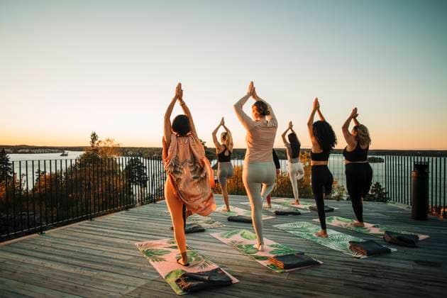 Rear view of female friends practicing Vrikshasana on patio at retreat center Sweden, Stockholm, model released, property released Copyright: xMaskotx , MA100357 MA100357