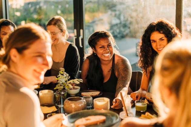 Happy woman communicating with female friends during breakfast at retreat center Sweden, Stockholm, model released, property released Copyright: xMaskotx , MA100409 MA100409