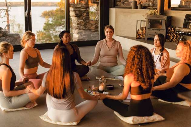 Multiracial female friends meditating together while sitting on floor at retreat center Sweden, Stockholm, model released, property released Copyright: xMaskotx , MA100457 MA100457