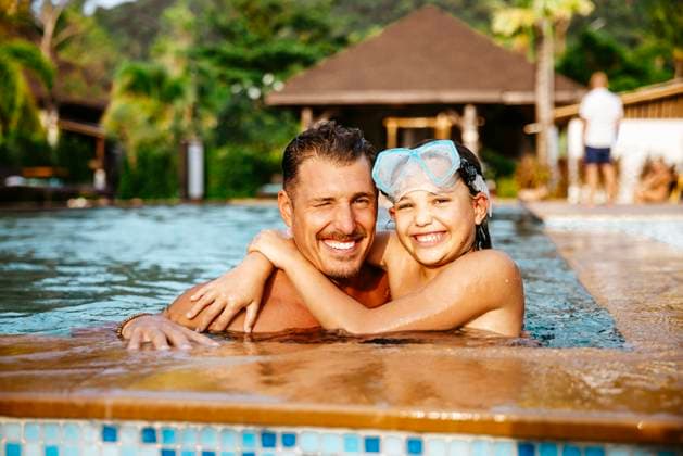 Portrait of smiling daughter and father in swimming pool at tourist resort Thailand, Ko Lanta, model released, property released Copyright: xMaskotx , MA100518 MA100518